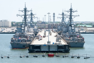 four large ships moored at a Navy base