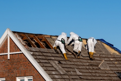 workers wearing protective gear while removing asbestos shingles